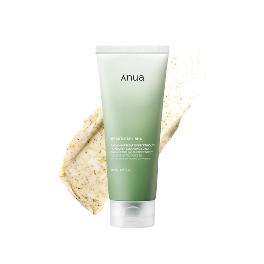 Green tube of anua cleanser with a beige product smear on a white background