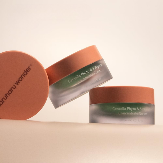 Three containers of Haruharu Wonder Centella Phyto & 5 Peptide Concentrate Cream on a beige background.