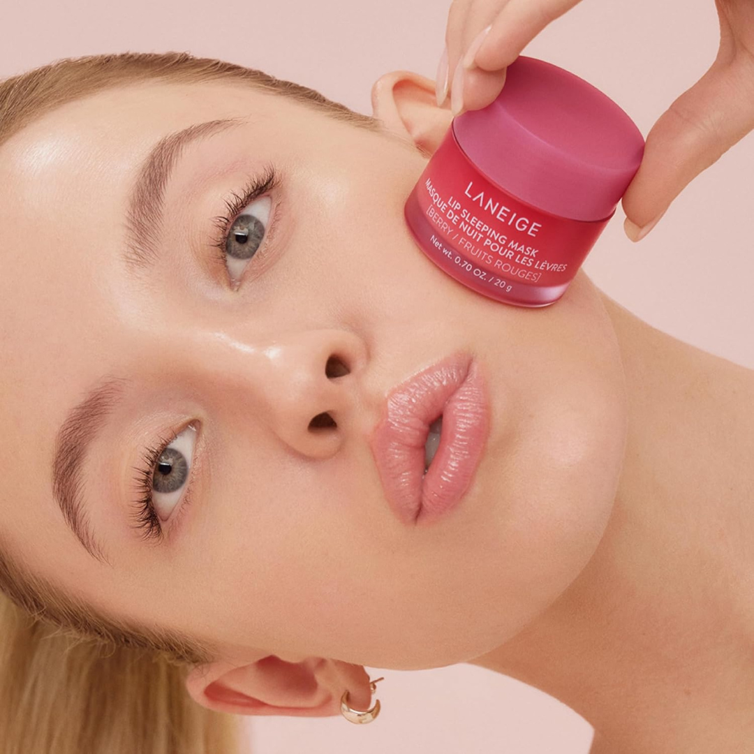 Woman holding LANEIGE Lip Sleeping Mask_EX (Berry) to her cheek and pouting