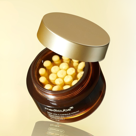Medicube Deep Vita C Capsule Cream with reflection on a light yellow background