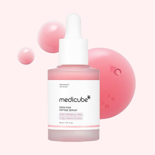 Medicube PDRN Pink Peptide Serum bottle with droplets on a light pink background