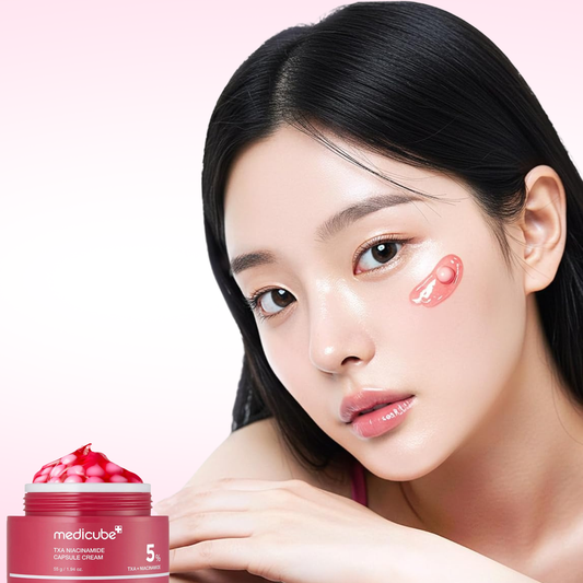 Woman with Medicube TXA Niacinamide Capsule Cream on her cheek with a jar of capsule cream in the foreground