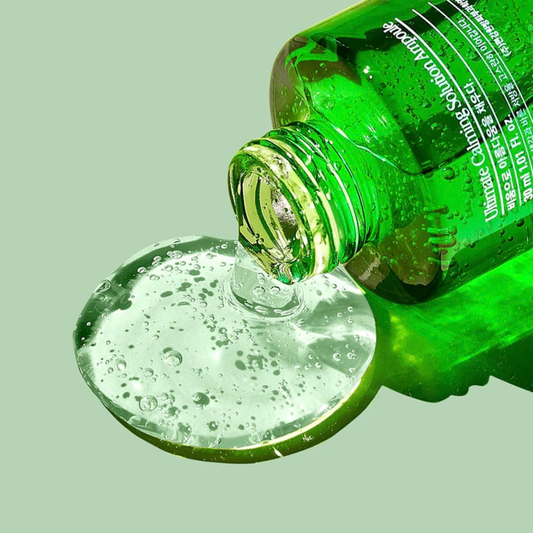 Pyunkang Yul Ultimate Calming Solution Ampoule bottle pouring liquid into a light green background