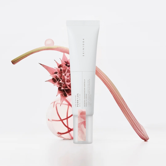 SKIN1004 Madagascar Centella PDRN 1.5 Cream tube styled with pink botanical elements on a white background