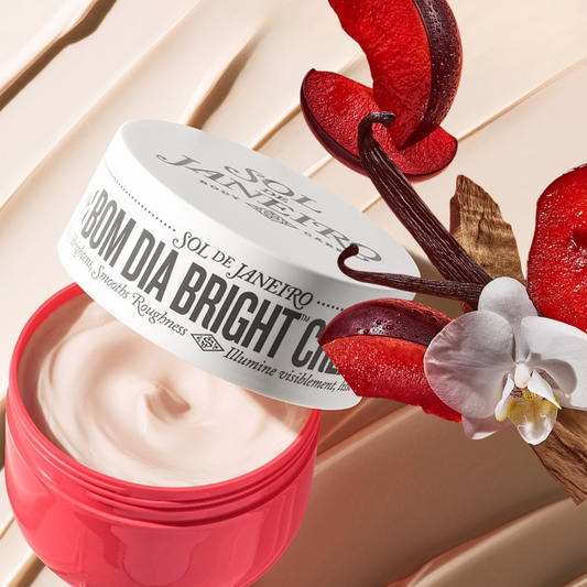 Jar of Sol de Janeiro Bom Dia Bright Cream with a white lid on a textured cream surface