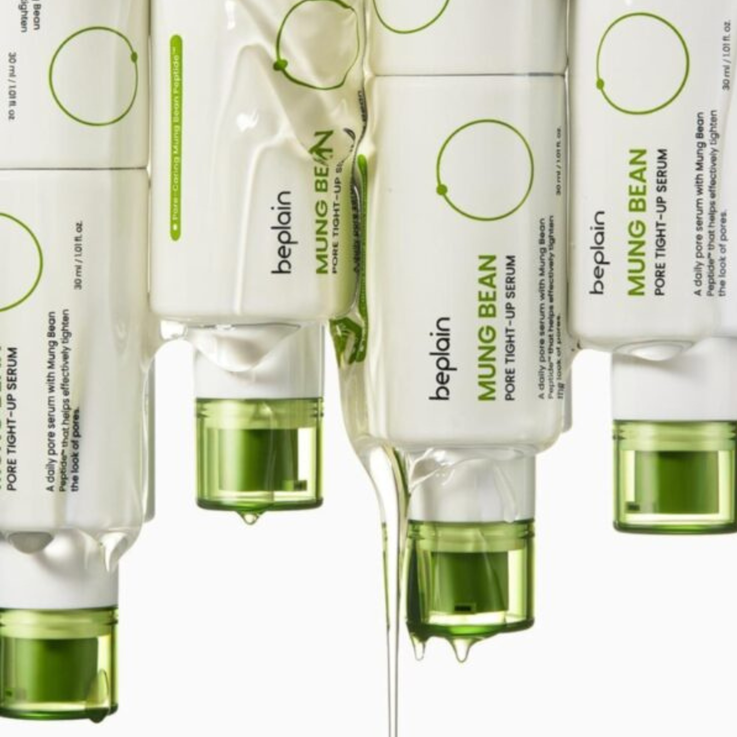 Multiple upside down bottles of beplain Mung Bean Pore Tight-Up Serum with green caps with serum dripping from them on a white background.
