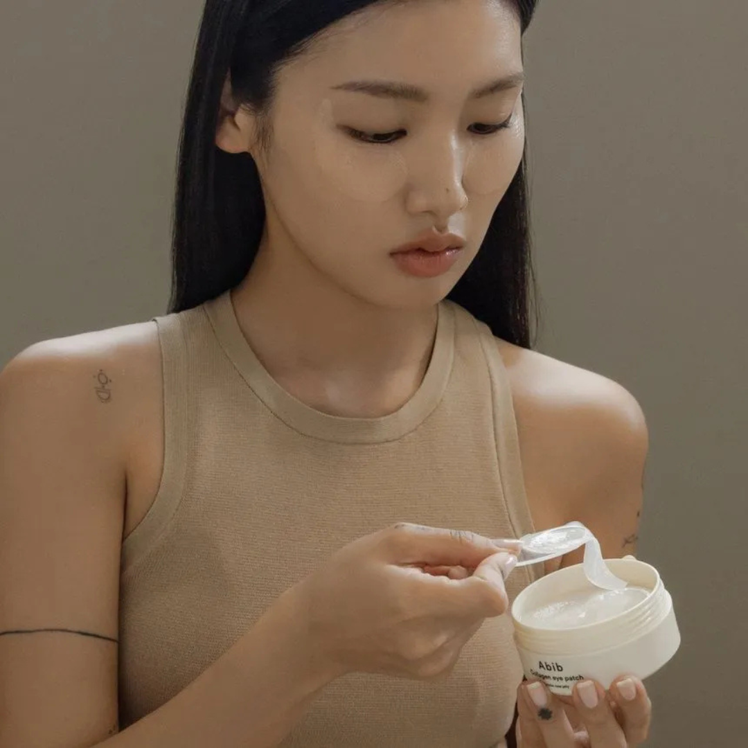 Woman applying Abib Collagen Eye Patch Jericho Rose Jelly with a neutral background
