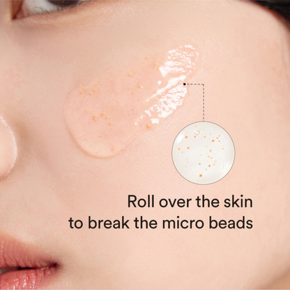 Close-up of skin with Abib Glutathiosome Dark Spot Serum Vita Drop application and text instructing to roll over the skin to break micro beads.