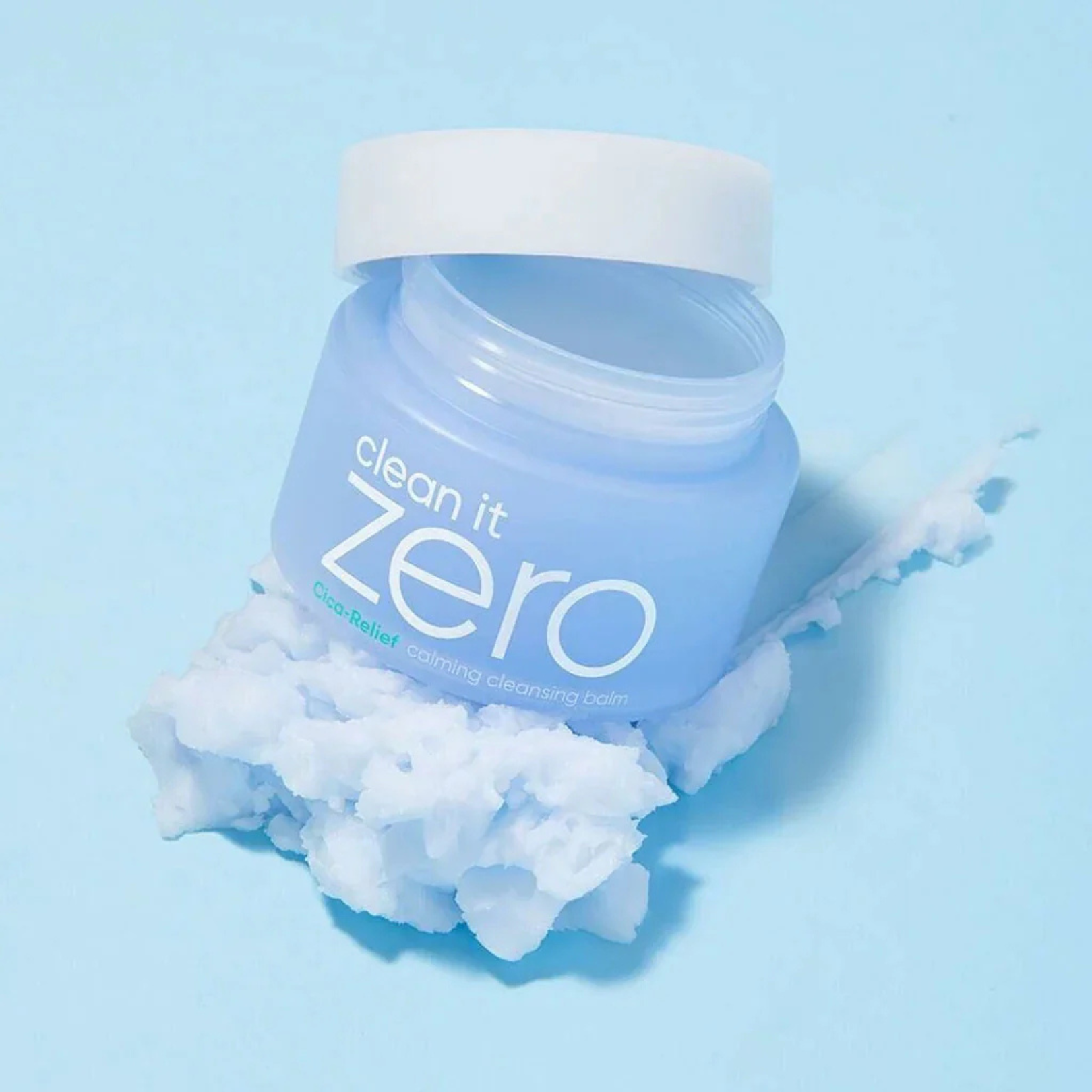 BANILA CO Clean It Zero Calming Cleansing Balm on a bed of cleansing balm on a light blue background