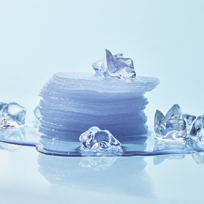 A stack of translucent,gel toner pads with scattered clear ice cubes on a glossy light blue surface against a pale blue background.