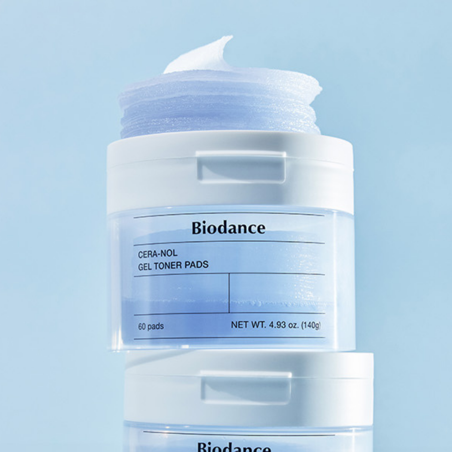 Biodance Cera-Nol Gel Toner Pads in a clear jar with a white lid and a blue-toned gel pad visible, shown against a light blue background with a second jar partially visible below.