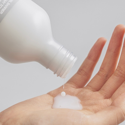 Close-up of Celimax Dual Barrier Creamy Toner being poured onto a hand to showcase the texture