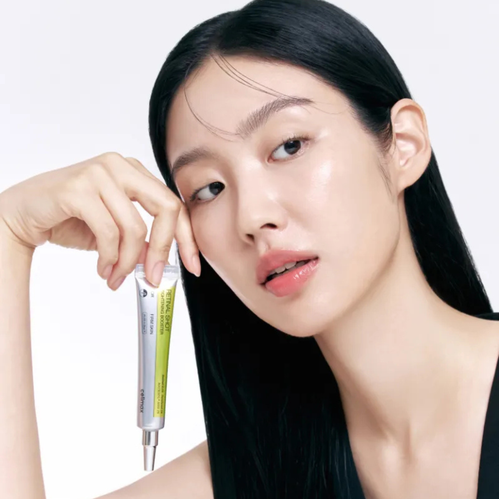 Woman holding Celimax Retinal Shot Tightening Booster with a plain background