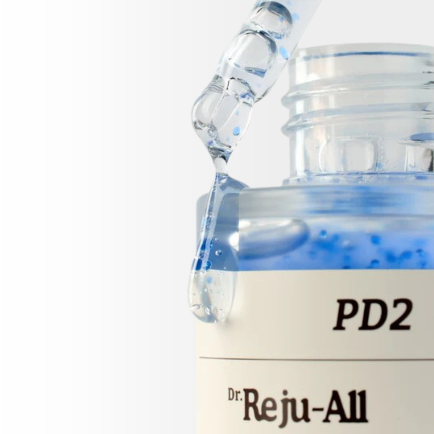 Close-up of a Dr. Reju-All Advanced PDRN Copper Peptide Serum bottle with a dropper dripping serum onto the side of the bottle on a white background.