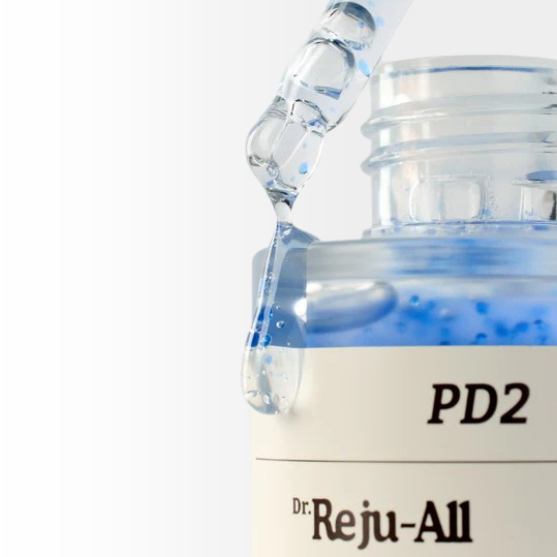 Close-up of a Dr. Reju-All Advanced PDRN Copper Peptide Serum bottle with a dropper dripping serum onto the side of the bottle on a white background.