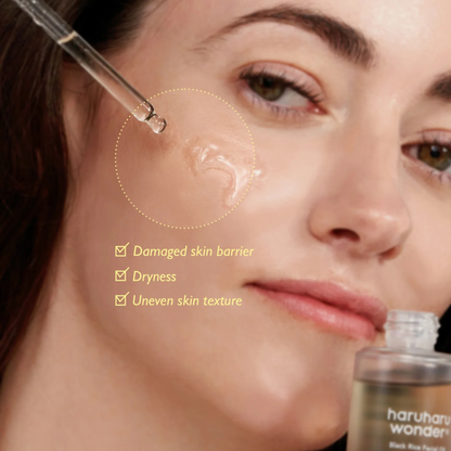Close-up of woman applying Haruharu Wonder Black Rice Facial Oil to her face with text on the product skincare benefits