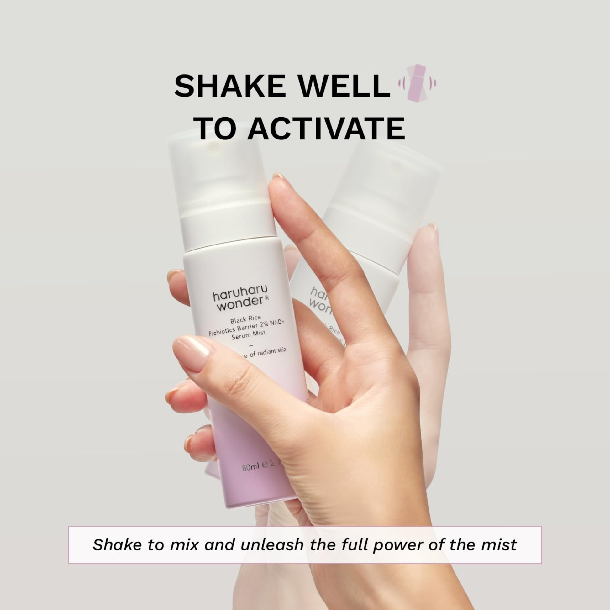 Hand holding Haruharu Wonder Black Rice Probiotics Barrier 2% NAD+ Serum Mist showing that the serum mist should be shaken to activate and mix the product.