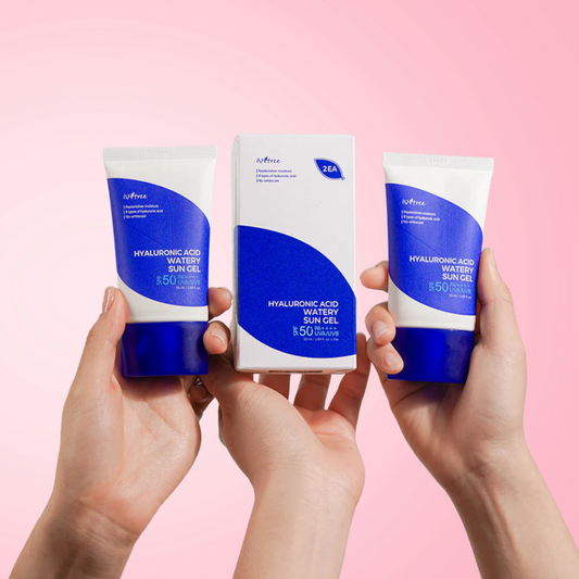 Three hands holding tubes of Isntree Hyaluronic Acid Watery Sun Gel SPF 50+ PA++++ against a pink background