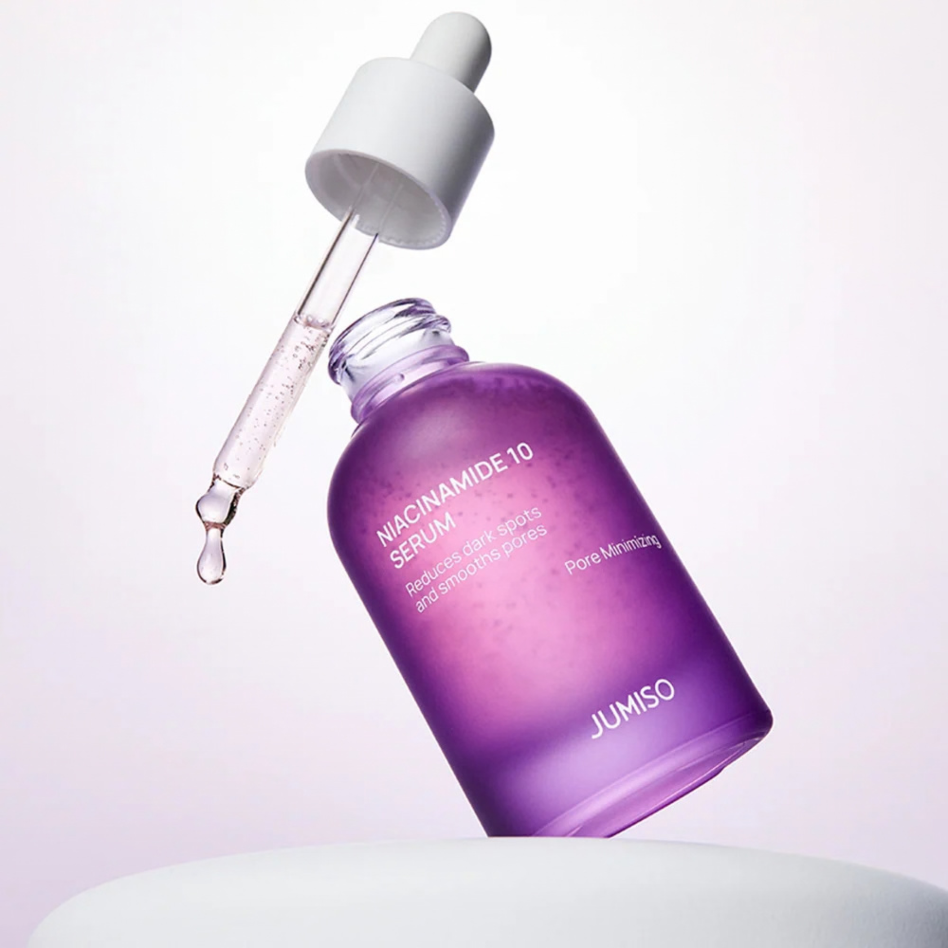 Purple Jumiso Niacinamide 10 Serum bottle with dropper on a light gray background