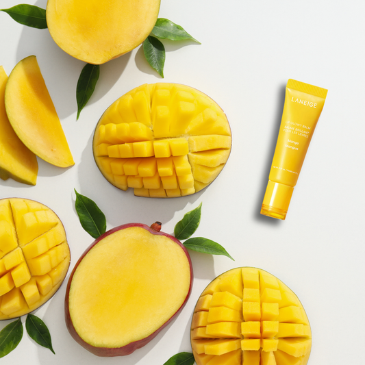 Mangoes and a Laneige Lip Glowy Balm (Mango) product on a white background