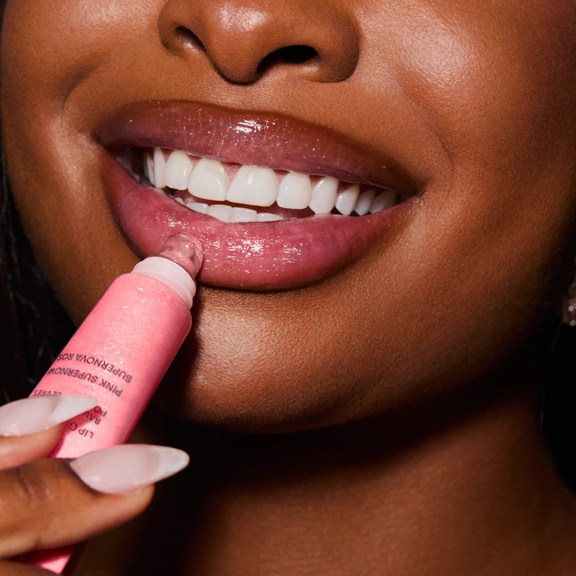 Close up of Woman applying LANEIGE Lip Glowy Balm (Pink Supernova)