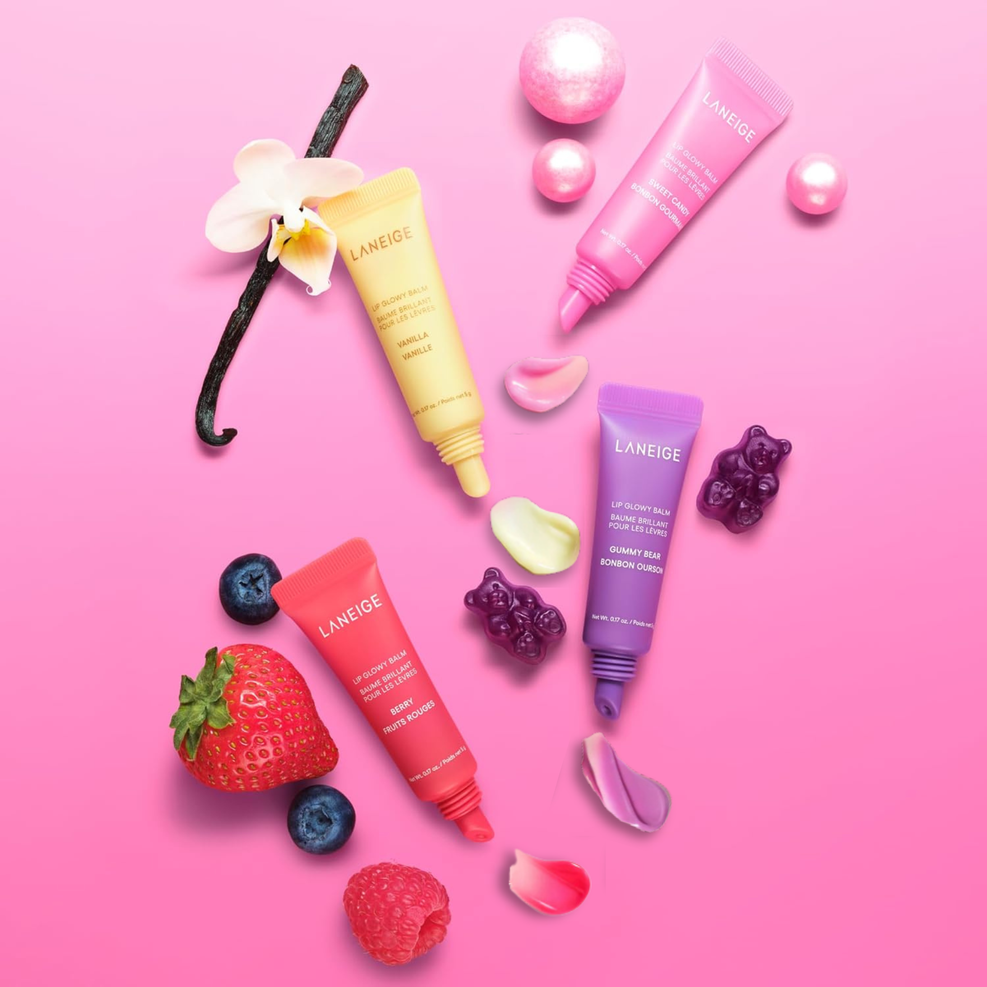 LANEIGE Mini Lip Glowy Balm Set (4pc) with fruits and flowers on a pink background