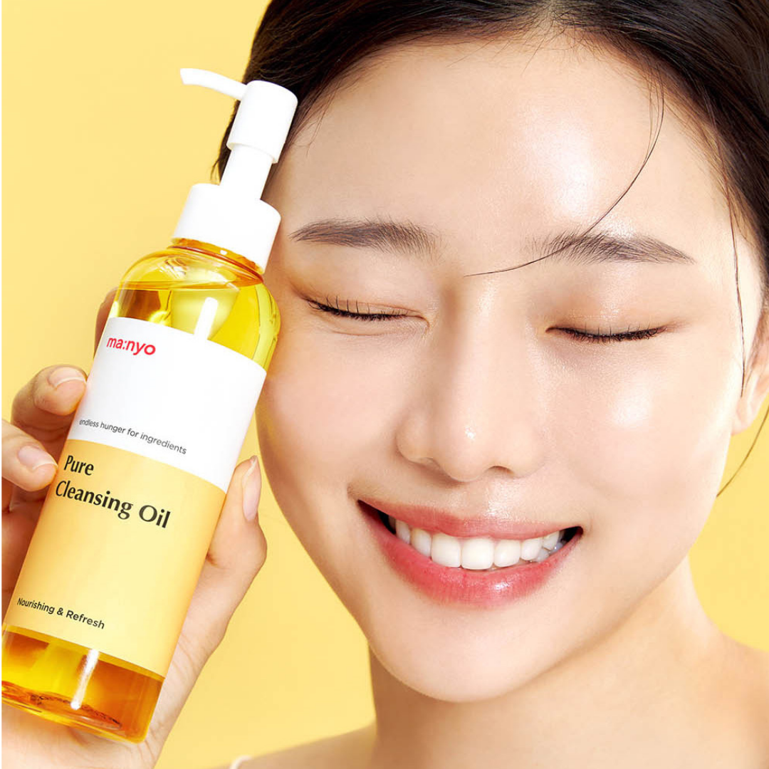 A woman with closed eyes holds a bottle of manyo Pure Cleansing Oil next to her face against a bright yellow background.