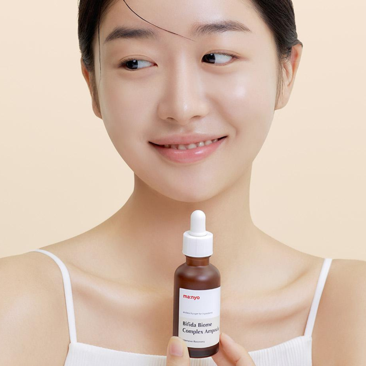 Woman holding a Ma:nyo Bifida Biome Complex Ampoule close to her chest