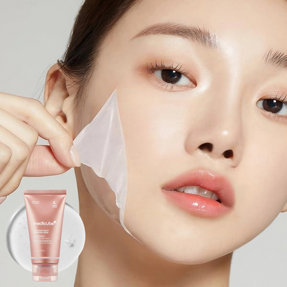 Woman peeling away Medicube Collagen Night Wrapping Mask with a tube of Medicube Collagen Night Wrapping Mask in the foreground.