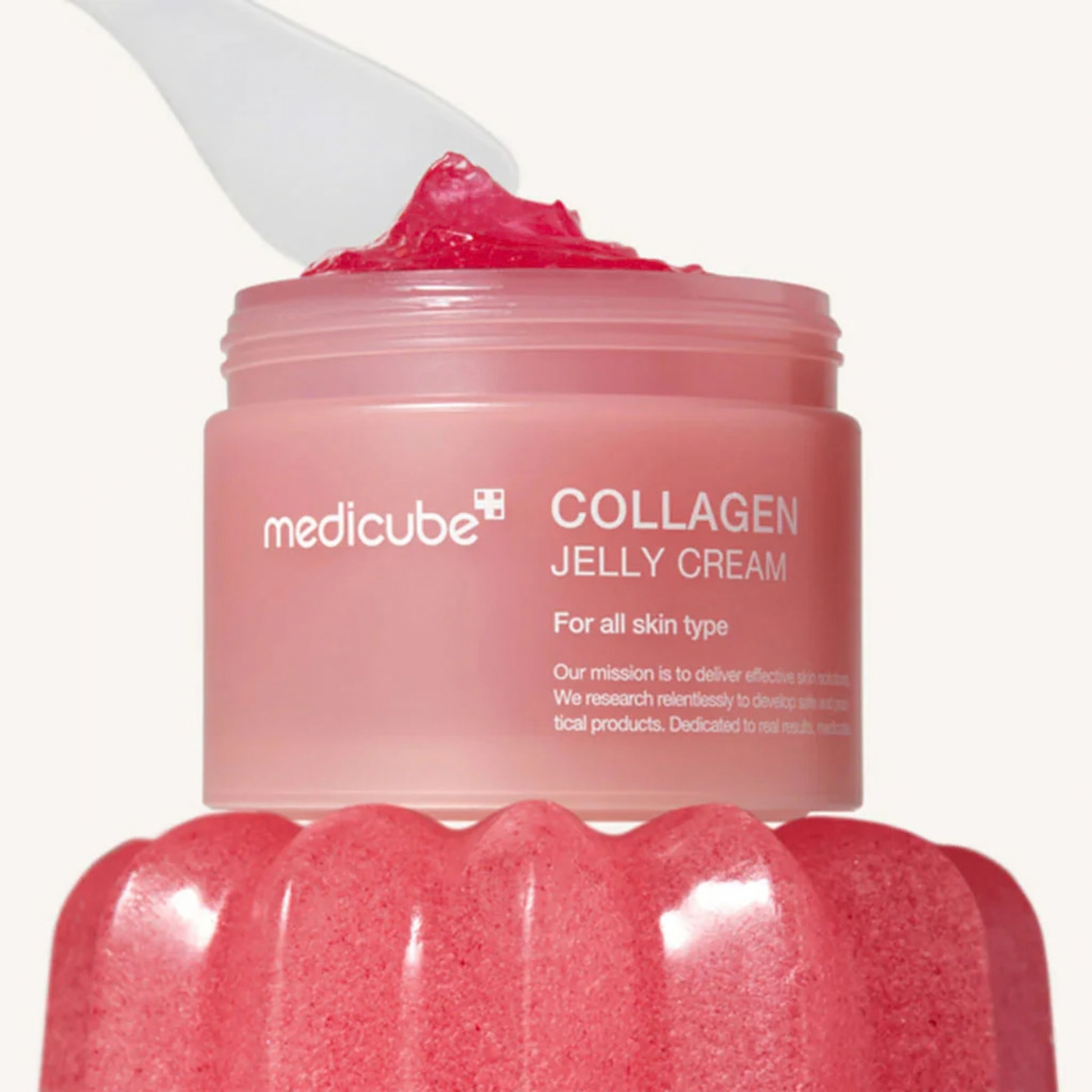 Pink Medicube Collagen Jelly Cream jar with a scoop on top of a pink moulded jelly on a white background
