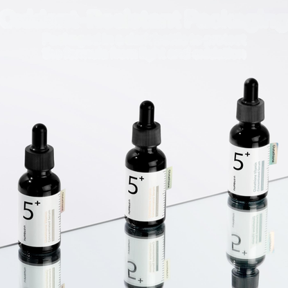 Three bottles of Numbuzin No.5 Glutathione Vitamin Concentrated Serum on a mirrored platform with a white background