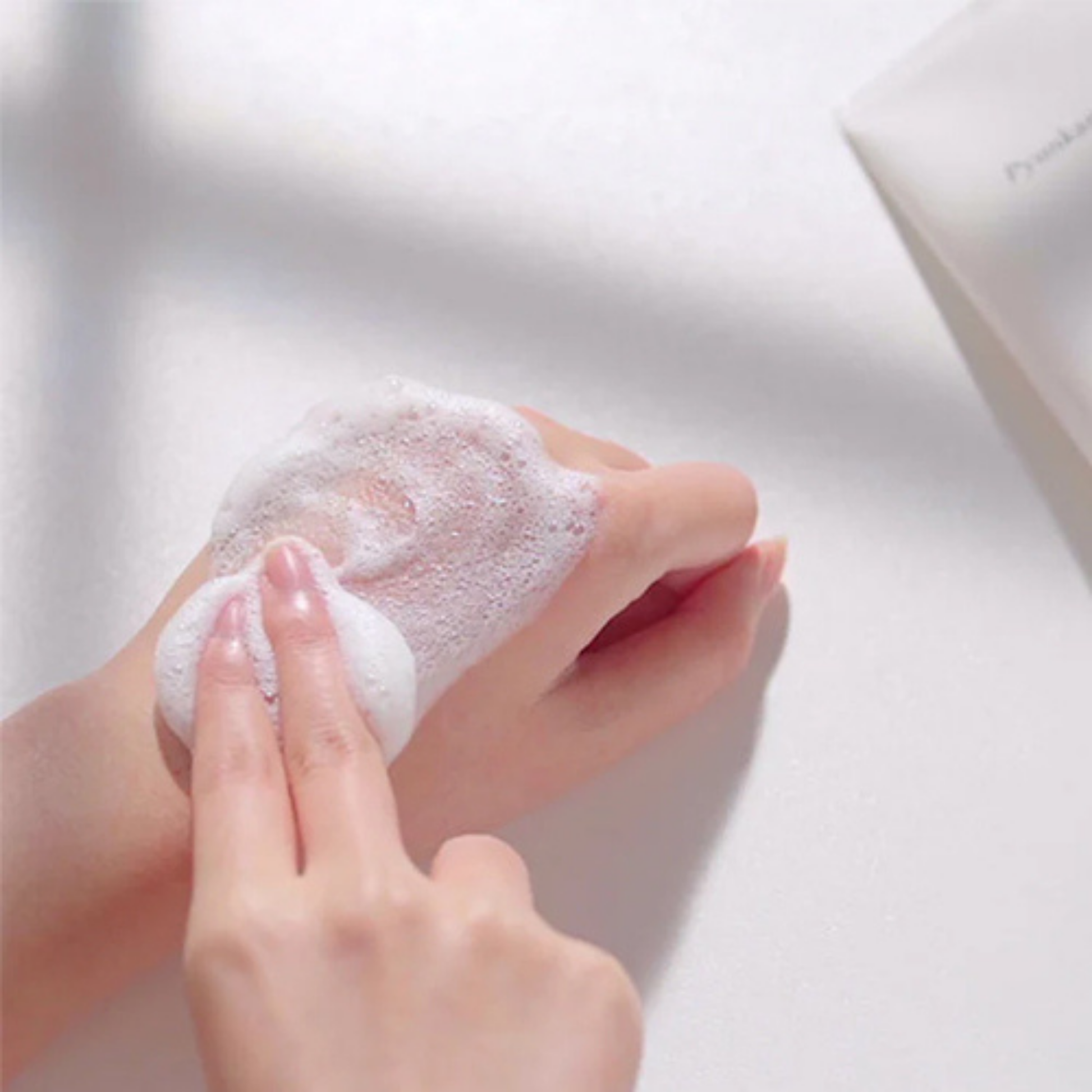 Person applying Pyunkang Yul
Cleansing Foam to hands with a blurred background