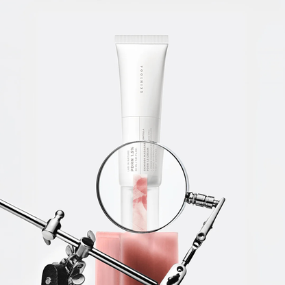 SKIN1004 Madagascar Centella PDRN 1.5 Cream tube viewed through a magnifying glass in a laboratory-style product setup