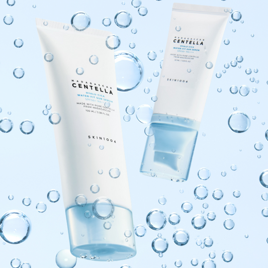 Skincare tubes of SKIN1004 Hyalu‑Cica Water‑Fit Sun Serum SPF 50+ PA++++ with water bubbles on a light blue background