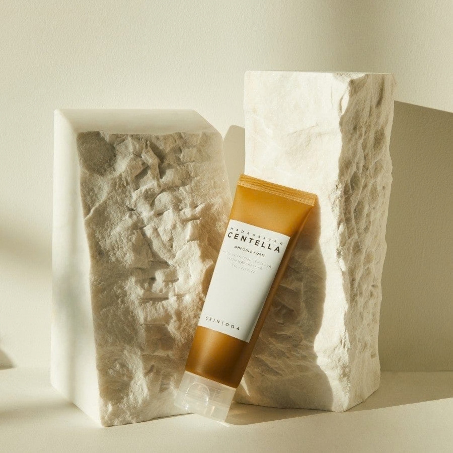 SKIN1004 Madagascar Centella Ampoule Foam tube angled against natural stone on a neutral background