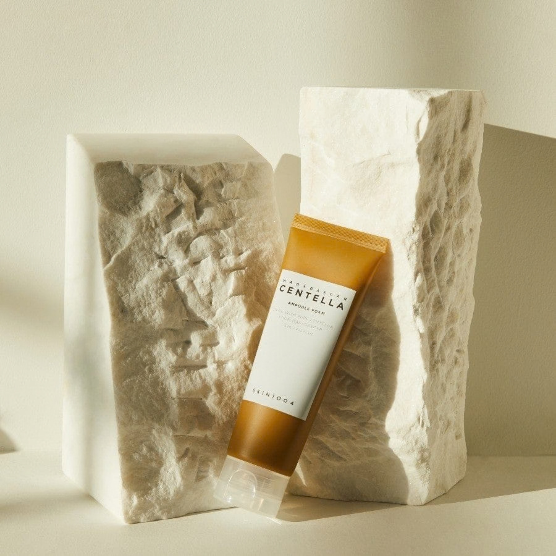SKIN1004 Madagascar Centella Ampoule Foam tube angled against natural stone on a neutral background