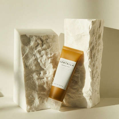SKIN1004 Madagascar Centella Ampoule Foam tube angled against natural stone on a neutral background
