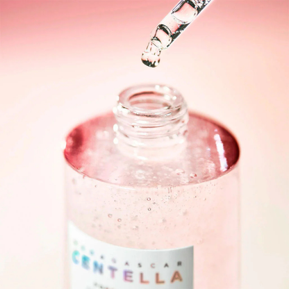 Close up of SKIN1004 Madagascar Centella Poremizing Fresh Ampoule with ampoule dropper on a light pink background