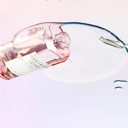 Bottle of SKIN1004 Madagascar Centella Poremizing Fresh Ampoule tipped over with the serum on a glass top