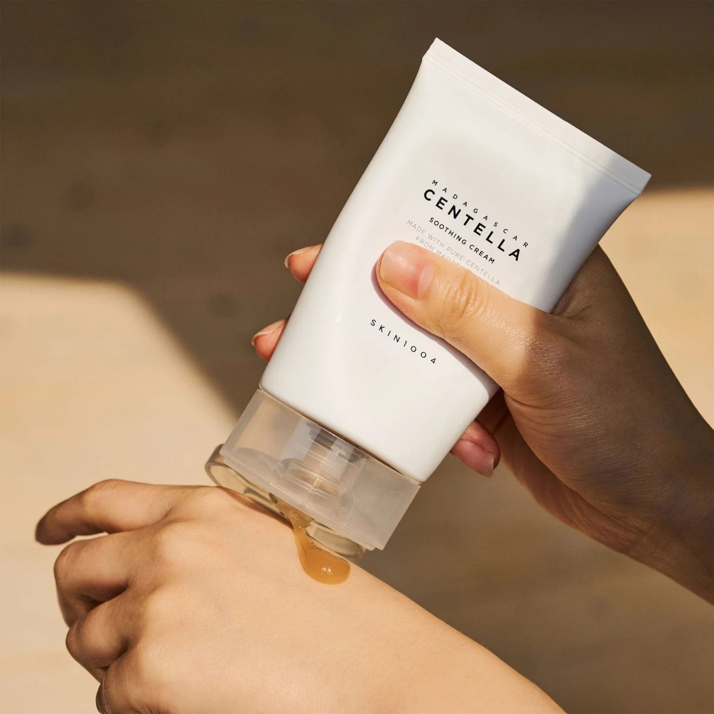 Hand applying SKIN1004 Madagascar Centella Soothing Cream to wrist with visible brand name