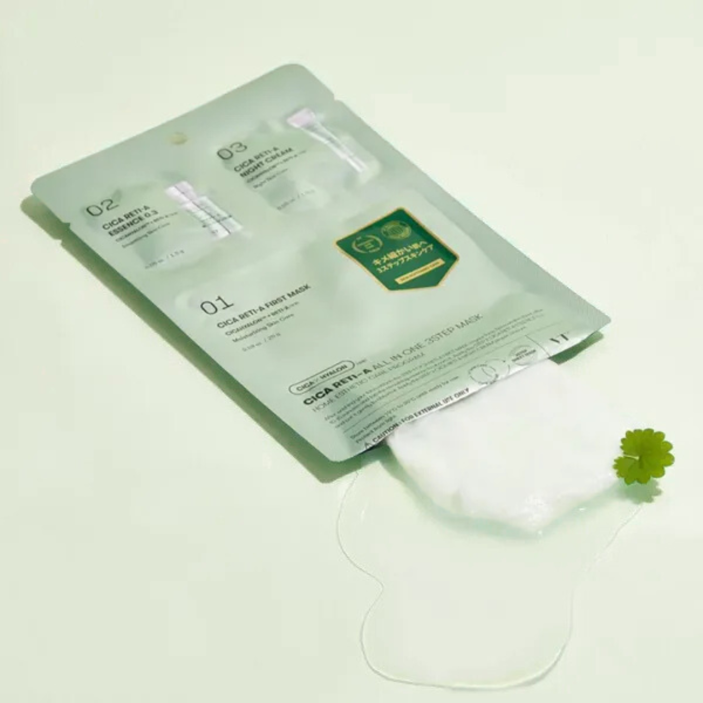 VT Cosmetics Cica Reti-A All in one 3 Step Mask opened and revealing the mask and serum as well as a centella asiatica leaf on a light green background