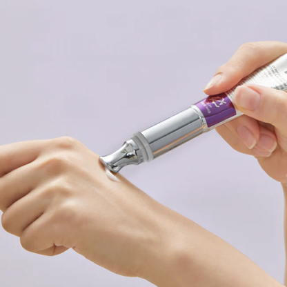 Hand holding a VT Cosmetics Reedle Shot Lifting Eye Cream against a light purple background
