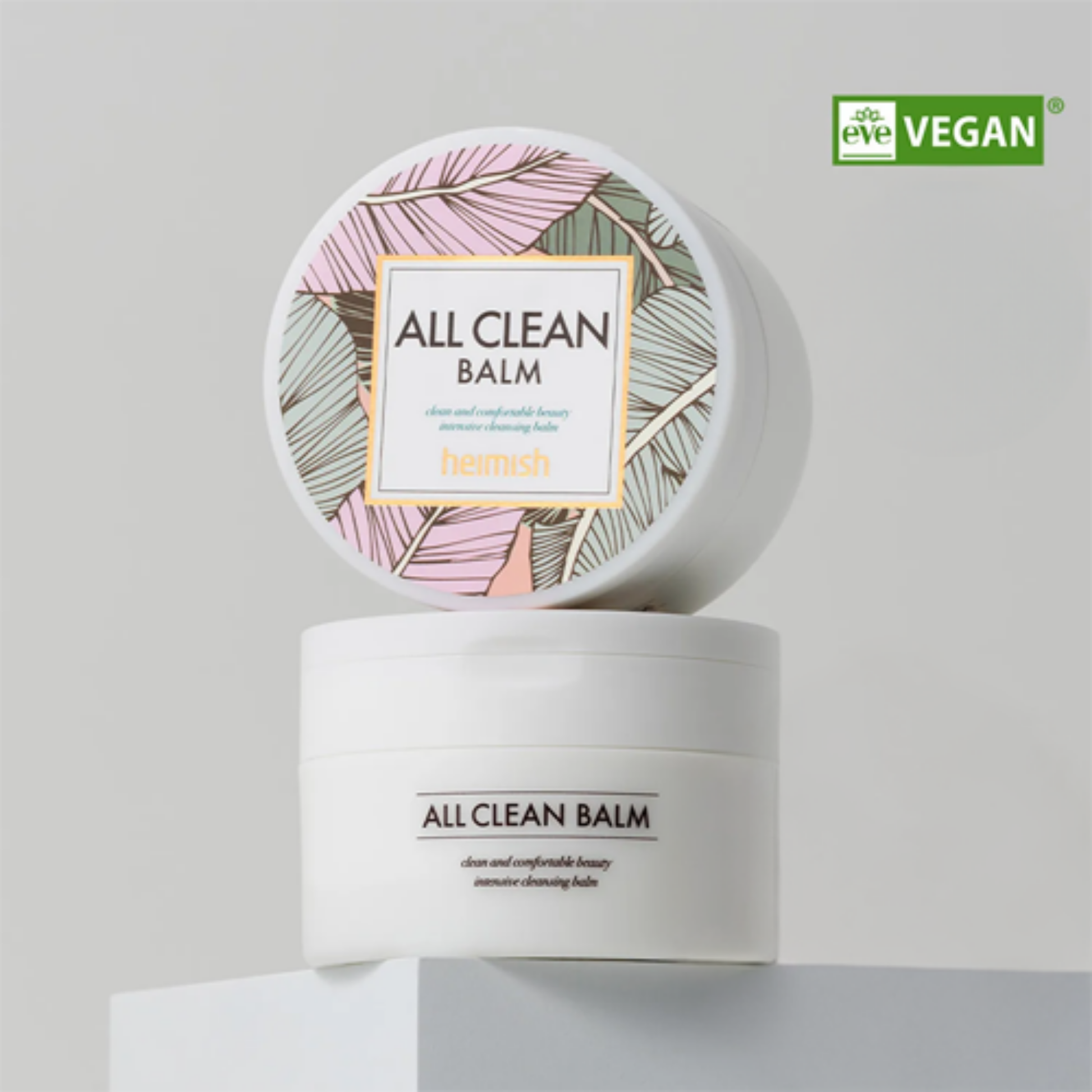 heimish All Clean Balm container with a decorative lid on a light gray background, featuring the Vegan certification logo.