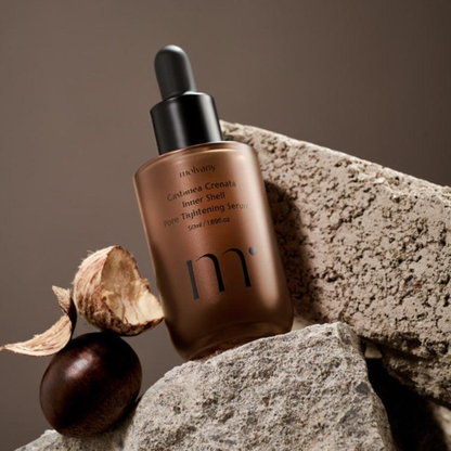 molvany Castanea Crenata Inner Shell Pore Tightening Serum serum bottle with dropper on a stone surface with a chestnut